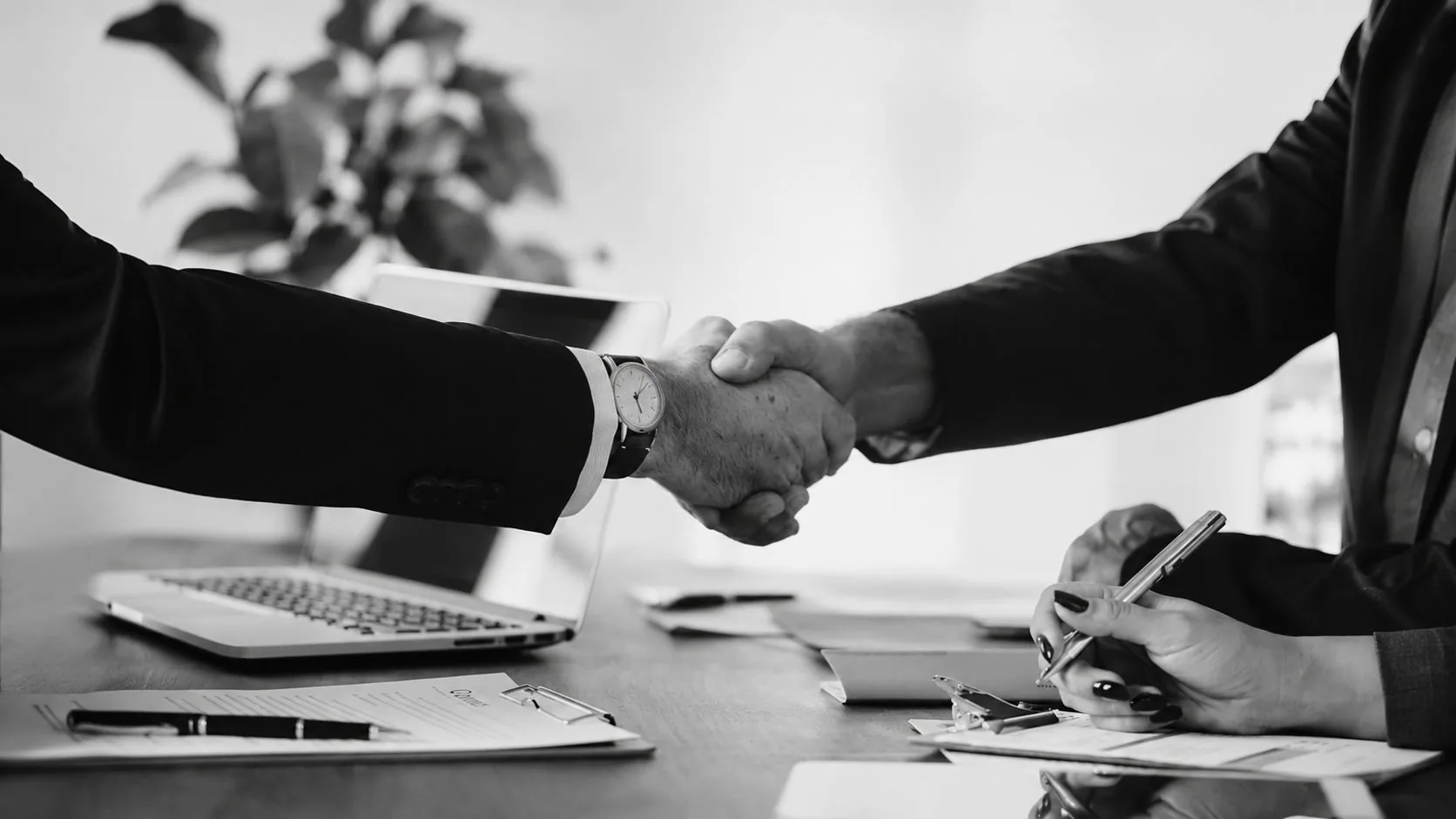 Apretón de manos entre un abogado del estudio y un cliente al cerrar una consulta